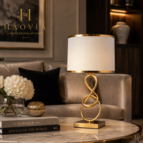 Lampe de chevet HAOVIA finition cuivrée coloris Rouge, posée sur une table basse marbrée avec fleurs et bougie